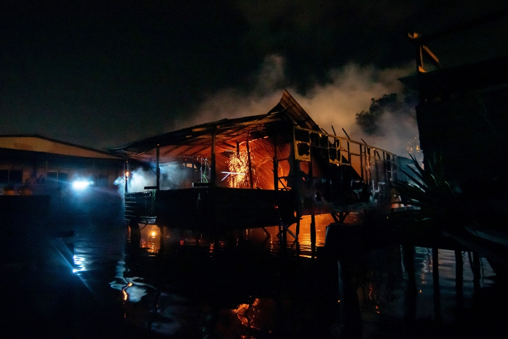 Labuan Fire and Rescue Department personnel work to put out the fire at the water village of Patau-Patau 2 February 11, 2024. — Bernama pic