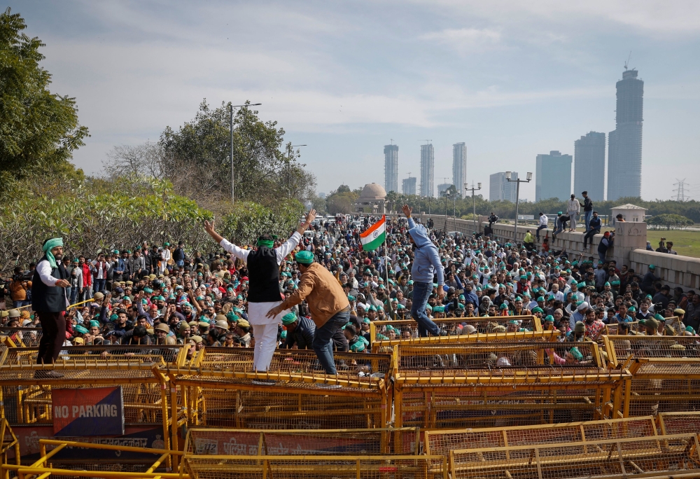 Farmers climb a police barricade during a protest demanding a hike in land compensation and better rehabilitation facilities for their families, in Noida on the outskirts of New Delhi, India, February 8, 2024. — Reuters pic