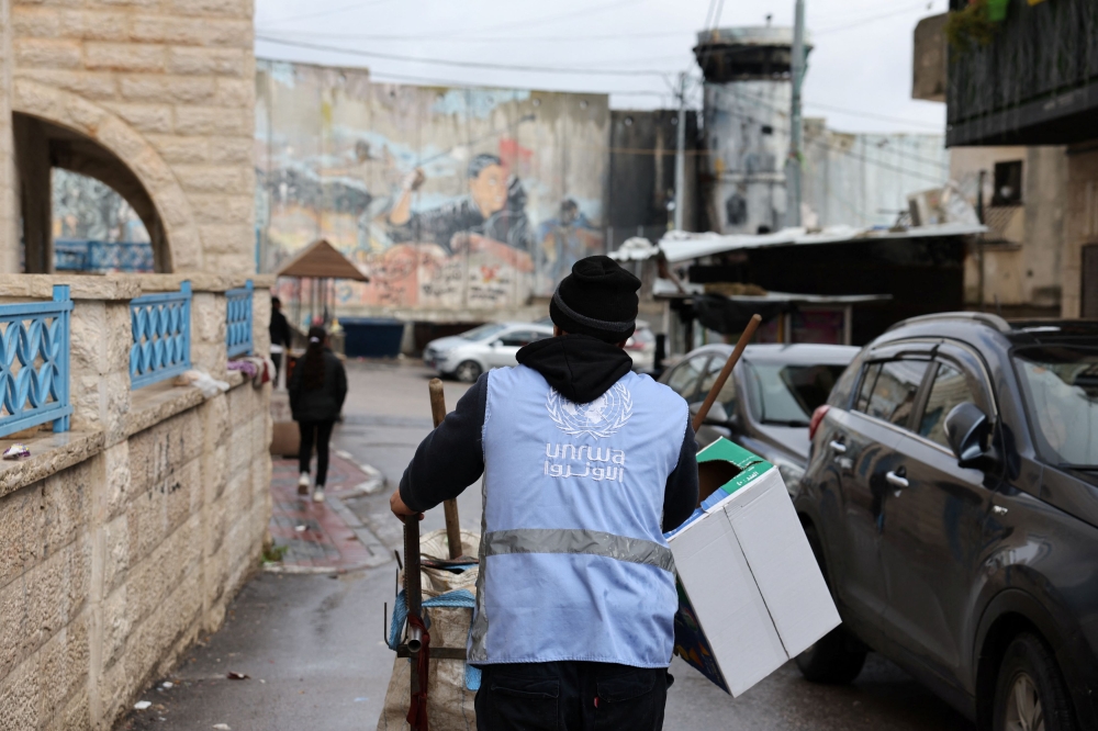 A UNRWA worker pushes a cart in the Aida refugee camp in Bethlehem in the Israeli-occupied West Bank, February 5, 2024. — Reuters pic