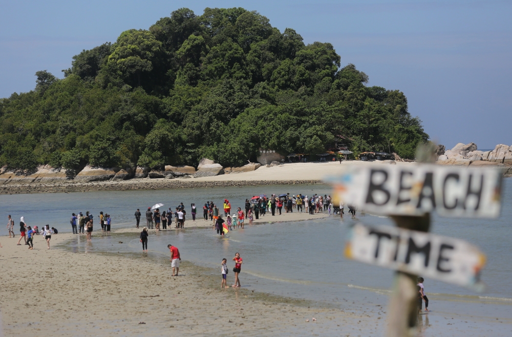 Tourists are seen walking on a 400-metre raised sandbank at Pulau Giam during the annual parting sea phenomenon February 12, 2024. — Bernama pic