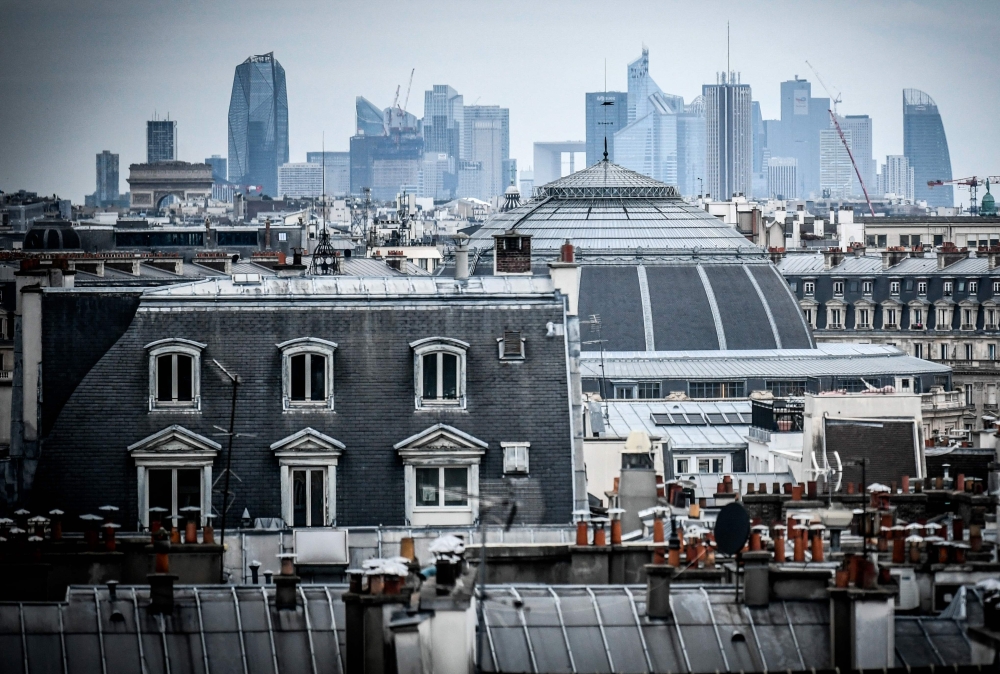 This photograph taken on February 6, 2024, shows a view of the roofs of Paris with the towers of La Defense business distric on the backgound in Paris. — AFP pic