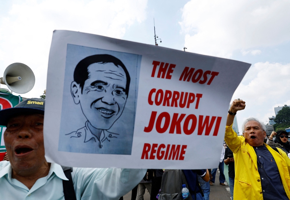 Anti-government protesters hold a banner denouncing Indonesia's outgoing President Joko Widodo during a rally demanding a fair election, outside the Indonesian parliament in Jakarta, Indonesia February 12, 2024. ― Reuters pic