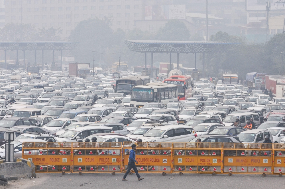 A man walks past barricades infront of vehicles stuck in heavy traffic at the New Delhi-Gurgaon Sirhaul expressway during a nationwide strike called by farmers on February 13, 2024. — AFP pic