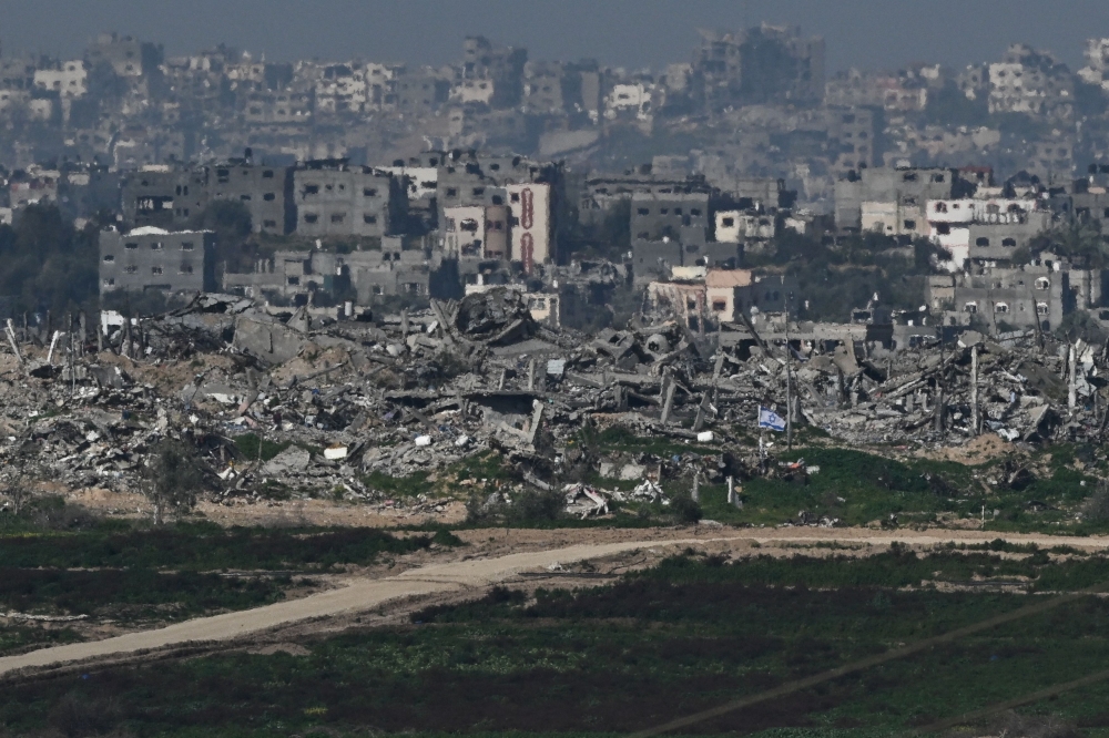 An Israeli flag flutters amid the ruins in Gaza, amid the ongoing conflict between Israel and the Palestinian Islamist group Hamas, as seen from Israel, February 13, 2024. — Reuters pic
