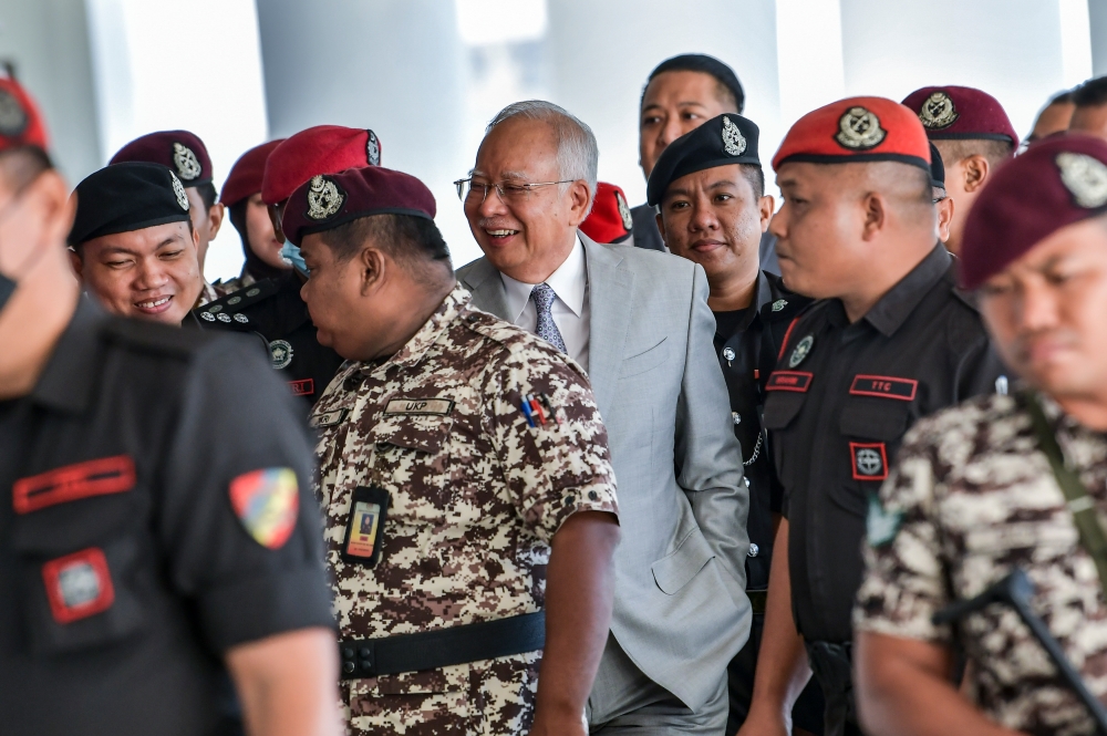 Former prime minister Datuk Seri Najib Razak is escorted by Prison Department personnel into the courtroom for the 1MDB trial at the Kuala Lumpur High Court Complex in Kuala Lumpur February 13, 2024. — Picture by Hari Anggara