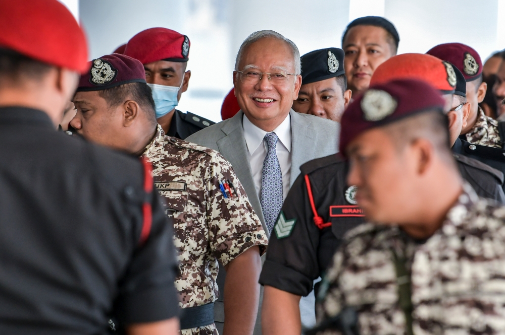 Former prime minister Datuk Seri Najib Razak is escorted by Prison Department personnel into the courtroom for the 1Malaysia Development Berhad (1MDB) trial at the Kuala Lumpur High Court Complex in Kuala Lumpur February 13, 2024. — Picture by Hari Anggara