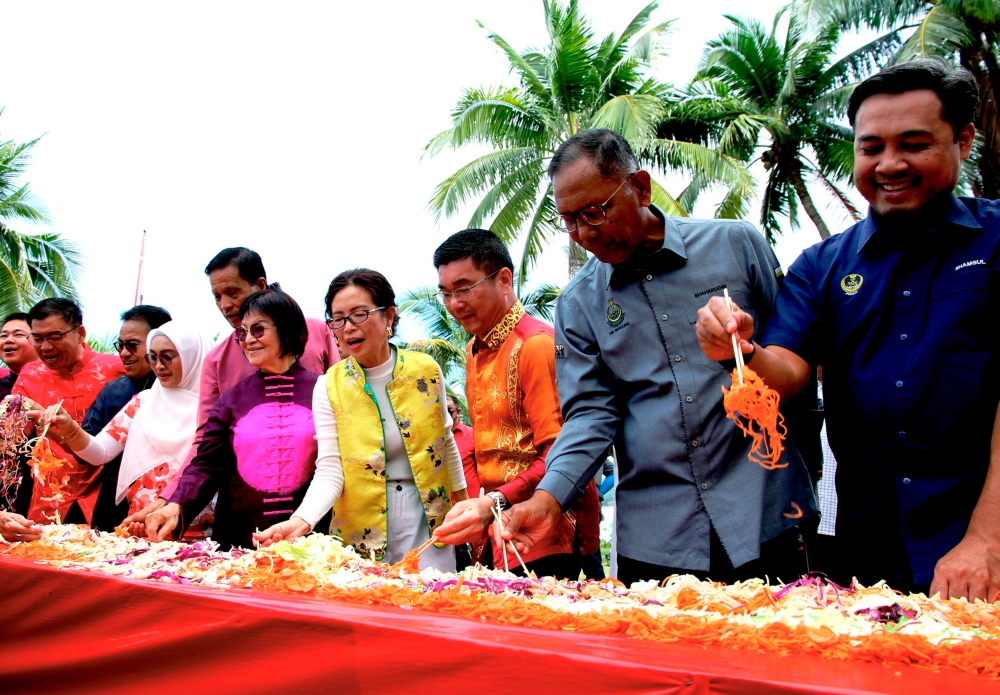 Perak Science, Environment and Green Technology Committee Chairman Teh Kok Lim (3rd right) and Marina Island CEO Ding Mei Looi (4th right) join Perak’s longest Yee Sang at the Toss To Prosperity Programme 2024 at Marina Island Complex Jetty February 13, 2024. — Bernama pic