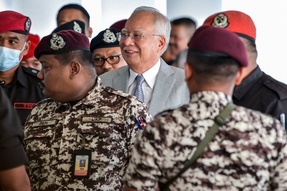 Former prime minister Datuk Seri Najib Razak is escorted by Prison Department personnel into the courtroom for the 1MDB trial at the Kuala Lumpur High Court Complex in Kuala Lumpur February 13, 2024. — Picture by Hari Anggara