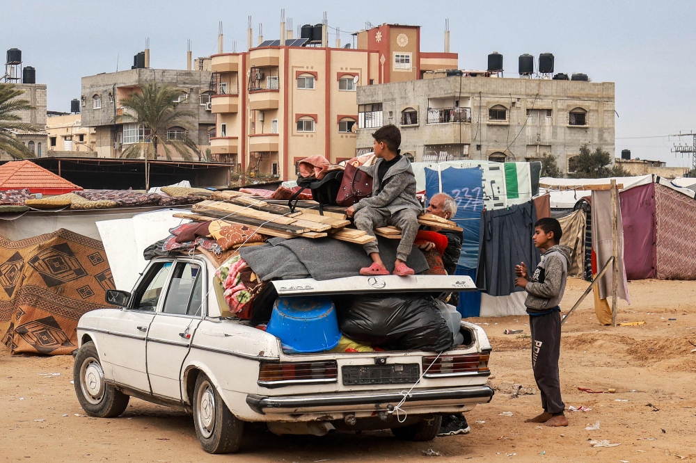 A child sits atop items secured onto a vehicle by rope as people flee from Rafah in the southern Gaza Strip on February 13, 2024 north towards the centre of the Palestinian territory amid the ongoing conflict between Israel and the Palestinian militant group Hamas. — AFP pic