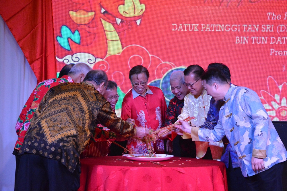 (From left) Dr Sim, Abang Johari, Wan Junaidi, Fauziah, and Juma’ani toss yee sang at the event. — Borneo Post Online pic