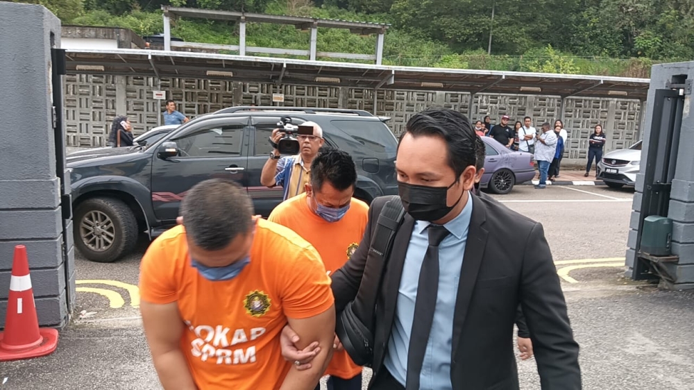 A Royal Malaysian Navy officer and a company owner are brought to the Johor Baru Magistrate’s Court February 14, 2024, where they were remanded for five days to assist a Malaysian Anti-Corruption Commission probe.  — Picture by Ben Tan