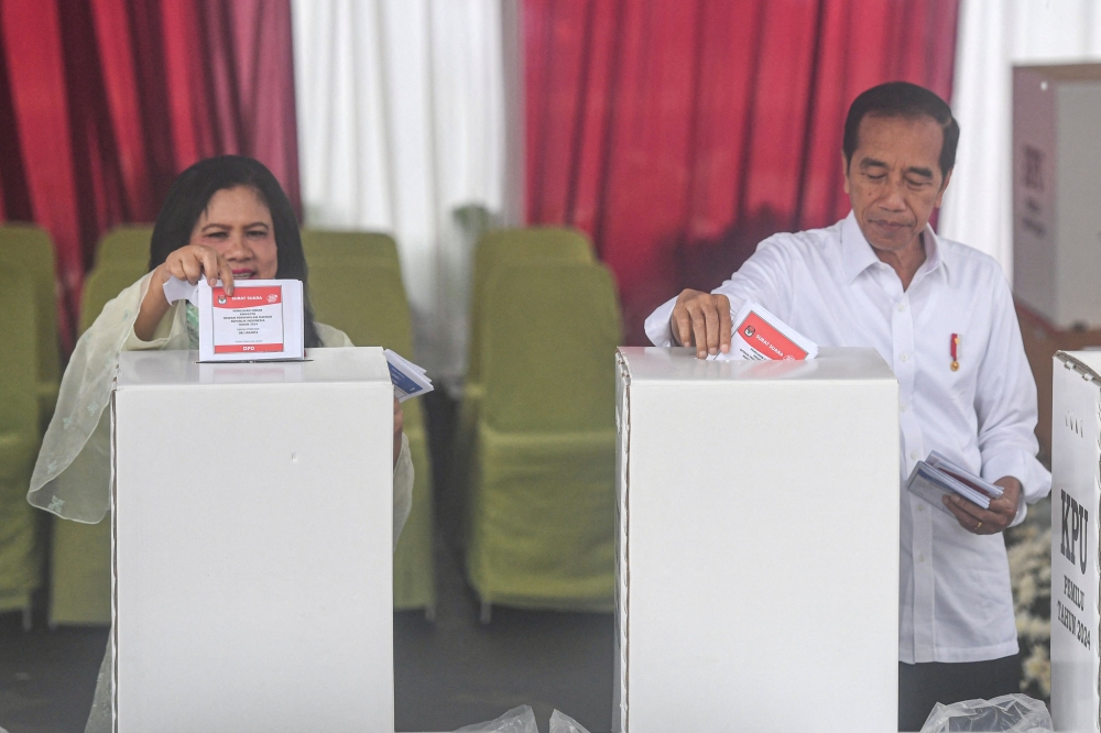 President Joko Widodo and First Lady Iriana cast their ballots at a polling station during the general election in Jakarta, Indonesia February 14, 2024. — Antara Foto/Muhammad Adimaja via Reuters pic