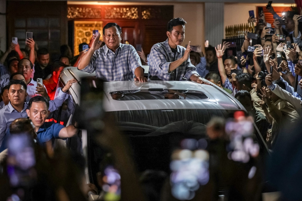 Former general Prabowo Subianto (left) claimed victory in Indonesia’s presidential election yesterday as preliminary results put him well ahead of his two rivals to lead South-east Asia’s biggest economy. — AFP pic