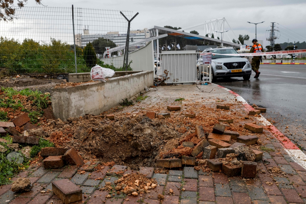 This picture taken on February 14 shows a view of an impact crater left by a rocket fired from southern Lebanon that landed near the entrance of Ziv hospital in Israel’s northern city of Safed. — AFP pic
