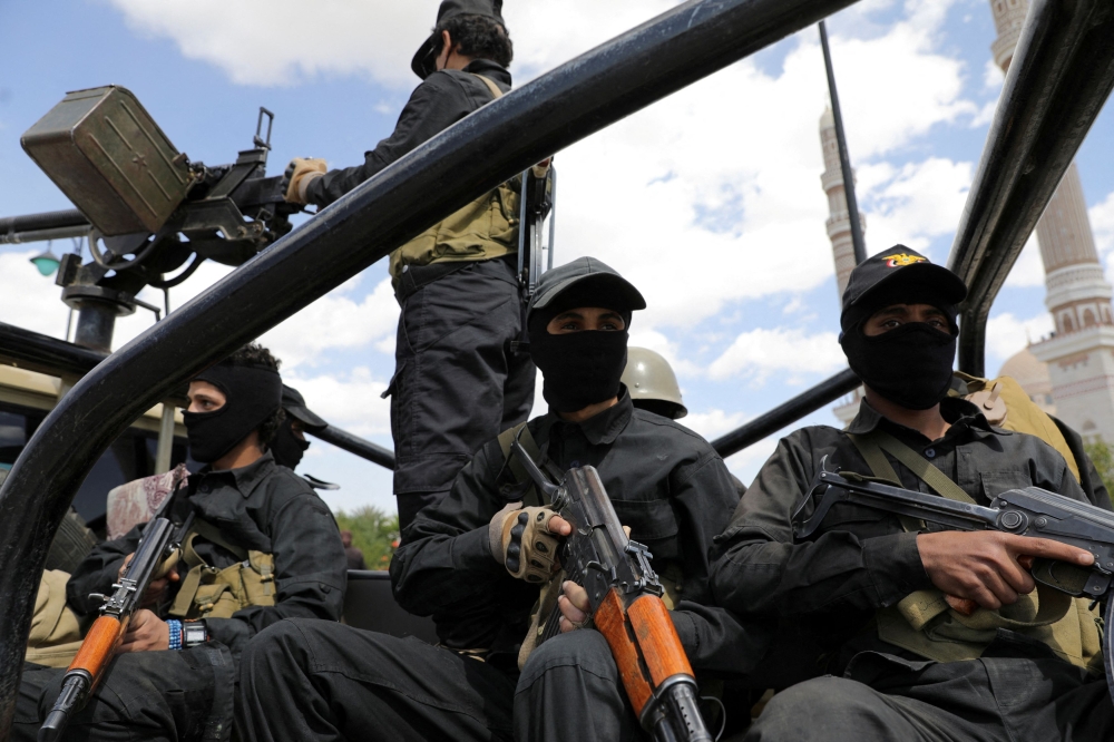 Houthi policemen ride on the back of a patrol pick-up truck during the funeral of Houthi fighters killed in U.S.-led strikes, in Sanaa, Yemen February 10, 2024. — Reuters pic