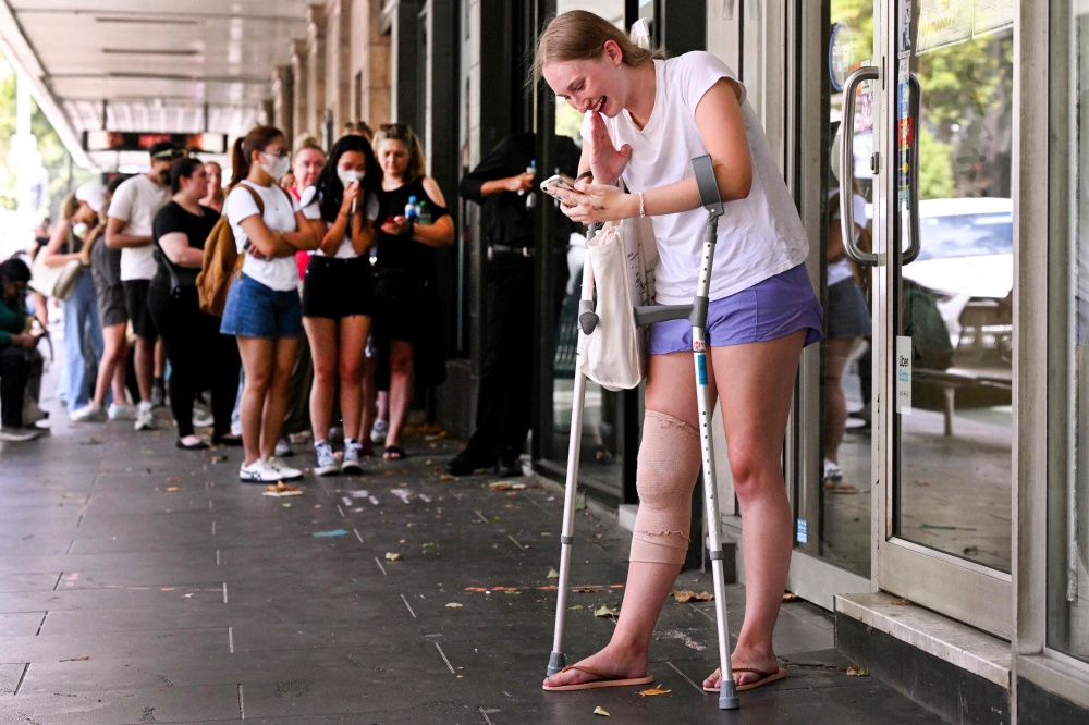 A fan of US singer Taylor Swift, also known as a Swiftie, reacts after securing a ticket in the final allocation for Swift's three shows in Melbourne on February 13, 2024. — AFP pic