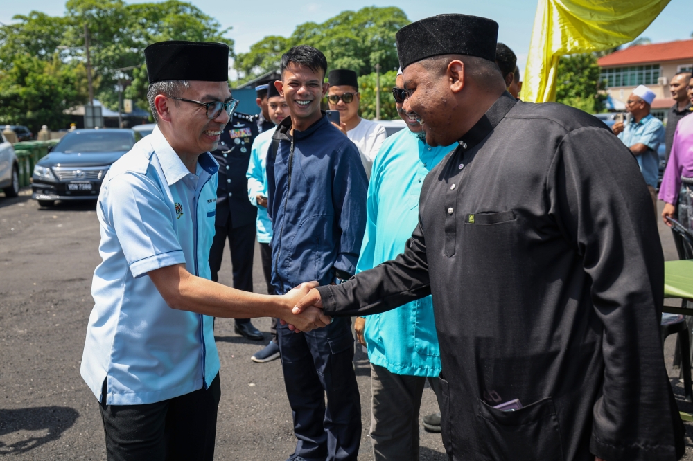 Communications Minister Fahmi Fadzil shakes hands with the public while attending the opening ceremony of Masjid Jamek Tengah Berapit Mosque in Bukit Mertajam, February 16, 2024. — Bernama pic 
