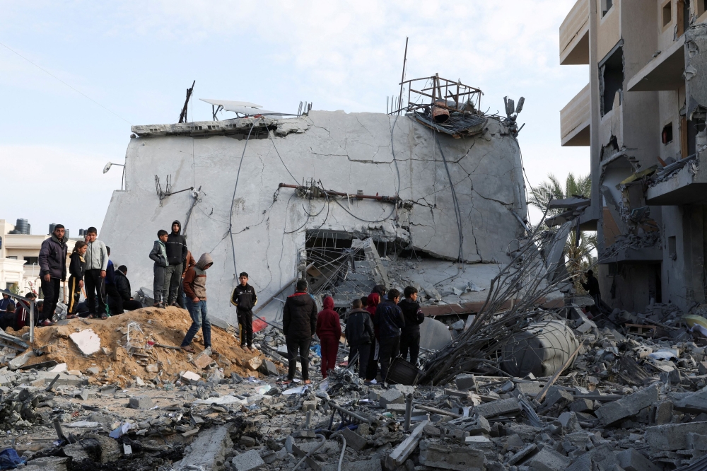Palestinians gather near a house hit by an Israeli strike, in Rafah in the southern Gaza Strip February 16, 2024. ― Reuters pic