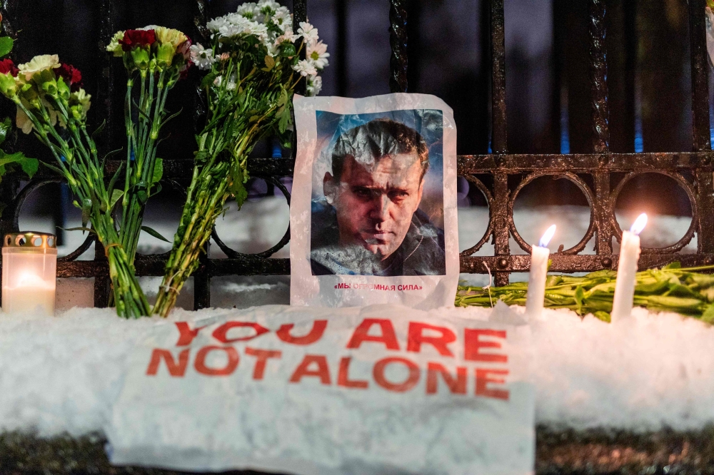 A portrait of Russian opposition leader Alexei Navalny and flowers are pictured during a rally in front of the Russian embassy in Oslo, Norway on February 16, 2024, following the announcement that the Kremlin’s most prominent critic had died in an Arctic prison. ― AFP pic