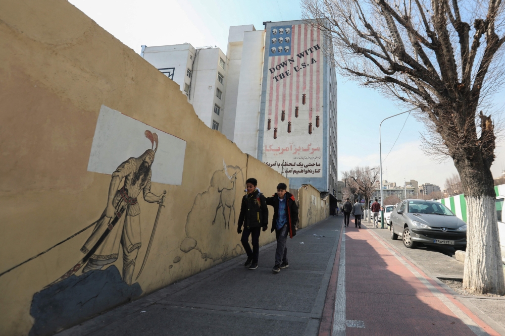 File photo of school children walking past an anti-US mural covering the wall of a building in the heart of the Iranian capital Tehran on January 30, 2024, amid tensions between Iran and the US over the regional repercussions of the ongoing Israeli-Palestinian conflict. — AFP pic