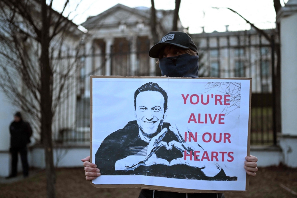 A demonstrator carries a placard with a picture of late Russian opposition leader Alexei Navalny as people gather to attend a rally in front of the Russian Embassy in Warsaw on February 16, 2024, following the announcement that the Kremlin’s most prominent critic Alexei Navalny had died in an Arctic prison. ― AFP pic