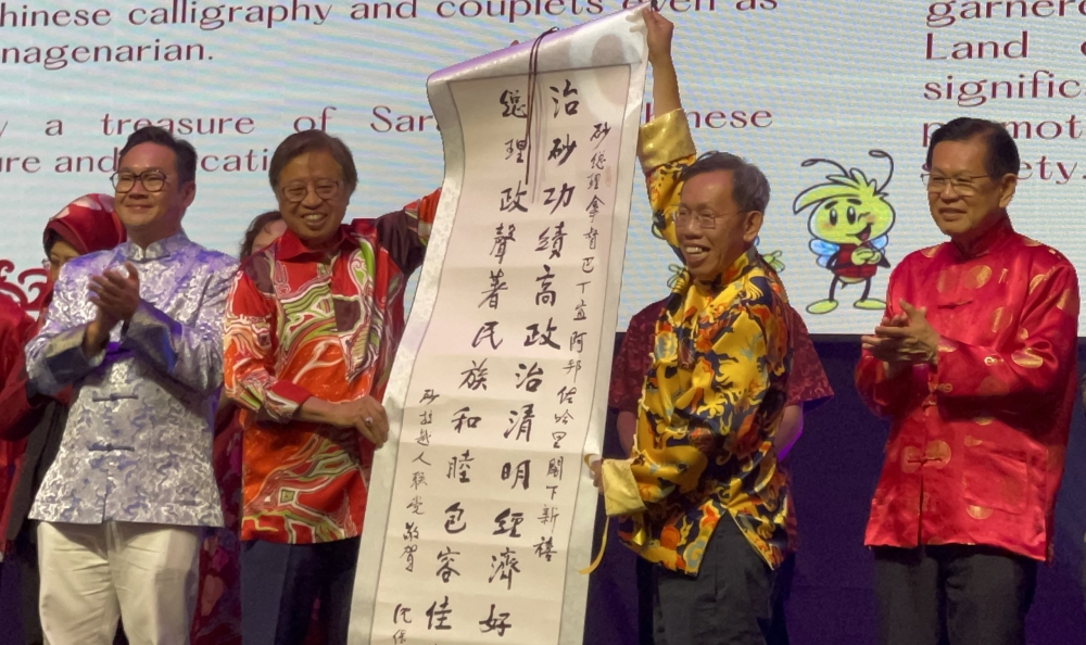 Dr Sim (2nd right) presents a special memento to Abang Johari, while Lee (right), Tiang (4th right) and others look on. — Picture by Jane Moh/Borneo Post