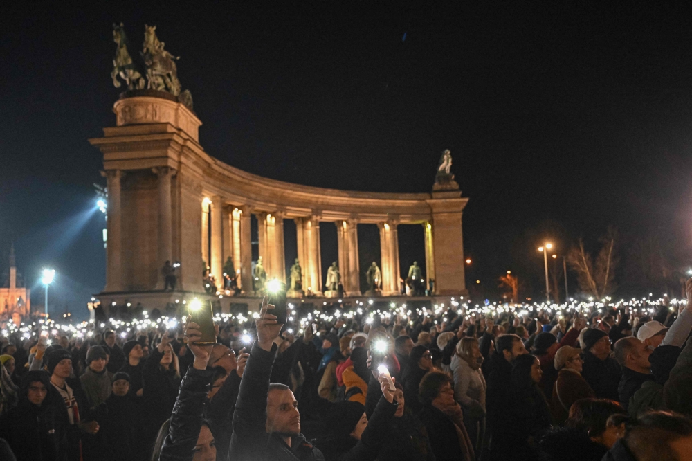 People light with their mobile phones as they demonstrate against Orban’s government policies at the Heroes’ Square in Budapest, Hungary on February 16, 2024. — AFP pic
