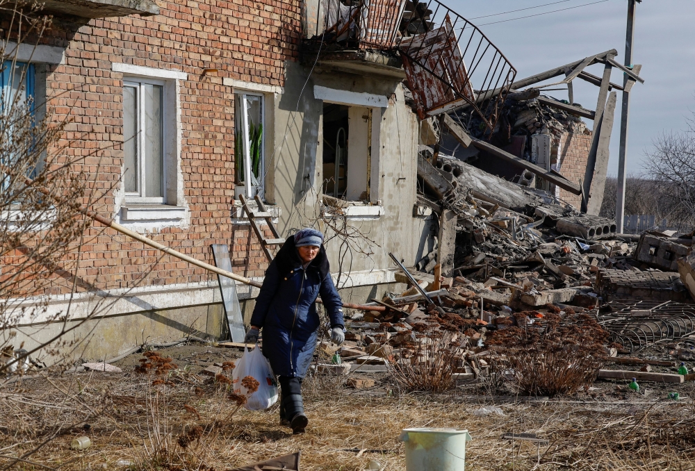 A local resident carries belongings out of an apartment building destroyed by recent shelling in the course of Russia-Ukraine conflict in the settlement of Panteleimonivka in the Donetsk region, Russian-controlled Ukraine, February 17, 2024. — Reuters pic