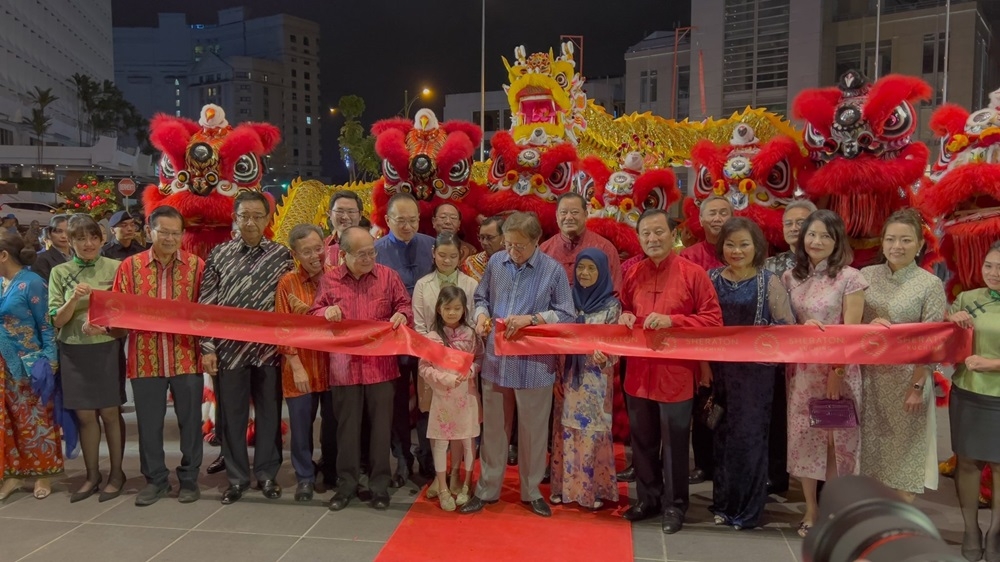 Abang Johari cuts the ribbon to symbolically officiate the grand opening of Sheraton Kuching Hotel while witnessed by Juma’ani (fifth right), Uggah (fifth left), Dr Sim (fourth left), Abdul Karim (third left), Lee (second left), Yee (fourth right) and other guests.  —  Borneo Post Online pic