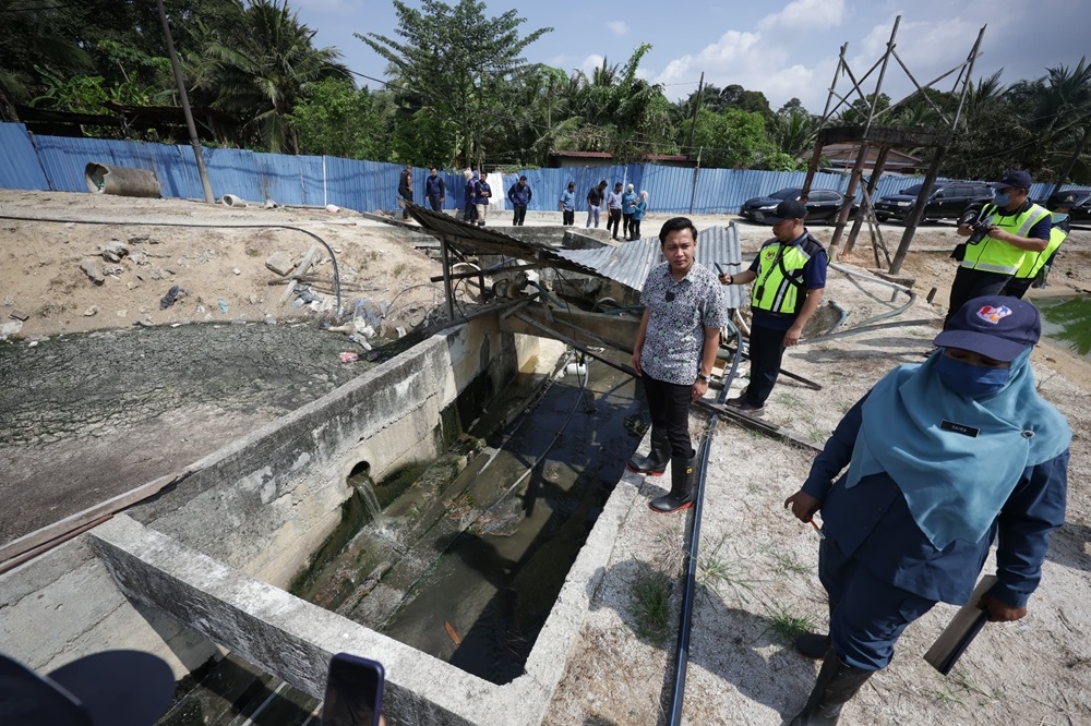 Penang Agrotechnology, Food Security and Cooperative Development Committee chairman Fahmi Zainol checking the drainage system at the duck breeding farm. — Picture by Opalyn Mok