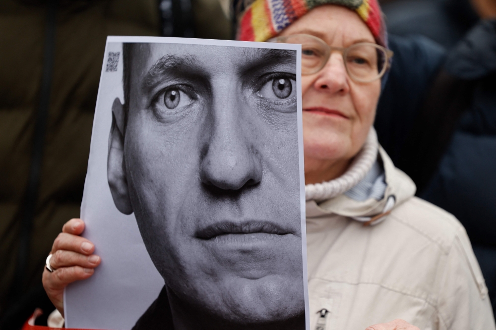 A woman holds a photo of Alexei Navaln at a memorial on February 18, 2024 in front of the Russian embassy in Berlin, following the death of the Kremlin's most prominent critic Alexei Navalny in an Arctic prison. — AFP pic