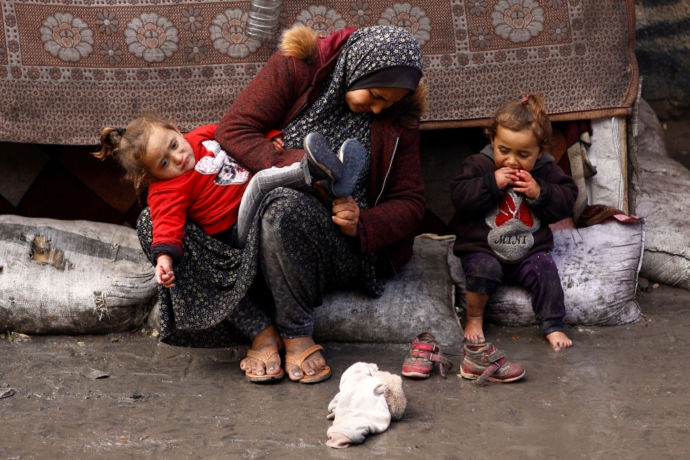 Displaced Palestinians, who fled their houses due to Israeli strikes, sit as they gather amid the ongoing conflict between Israel and Hamas, in Rafah in the southern Gaza Strip February 19, 2024. — Reuters pic