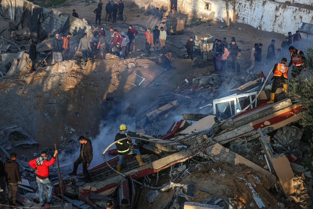 Members of the Palestinian civil defence extinguish a fire in a building following Israeli bombardments east of Rafah in the southern Gaza Strip on February 19, 2024, amid continuing battles between Israel and the Palestinian group Hamas. — AFP pic