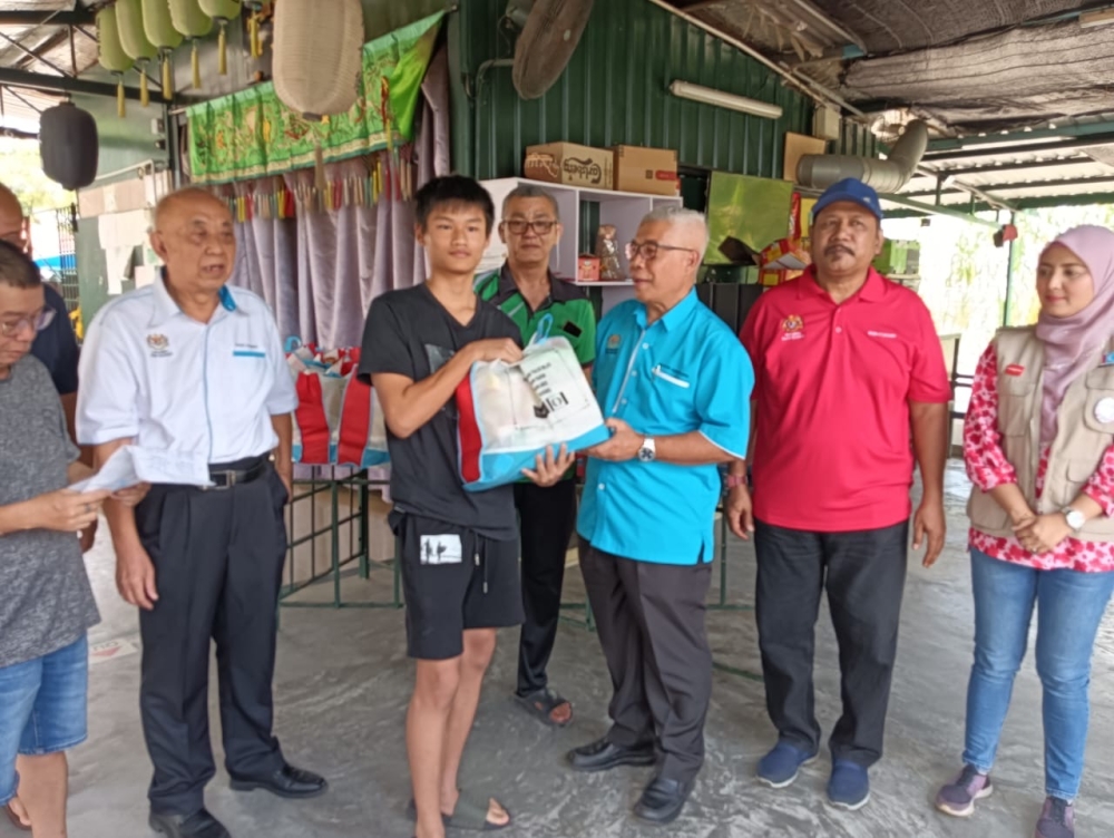 PKR’s Pasir Gudang MP Hassan Abdul Karim (centre) distributes food baskets to recipients from Rumah Pangsa Permas Jaya in Pasir Gudang February 20, 2024. — Picture by Ben Tan