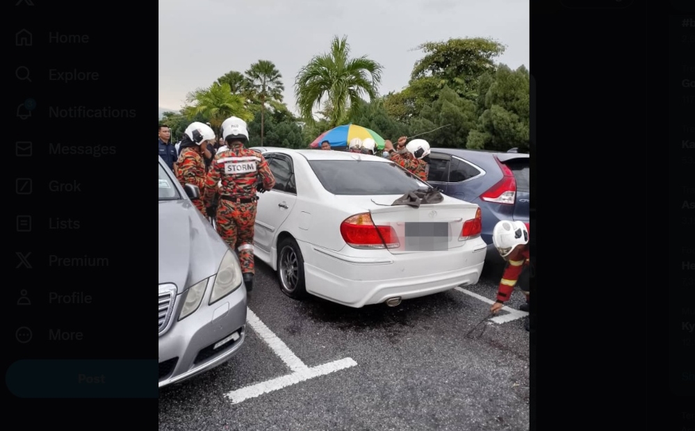 Firemen prying open the car door using specialised equipment to get to the woman inside, Ipoh, February 20, 2024. — Picture from X/Bernama 