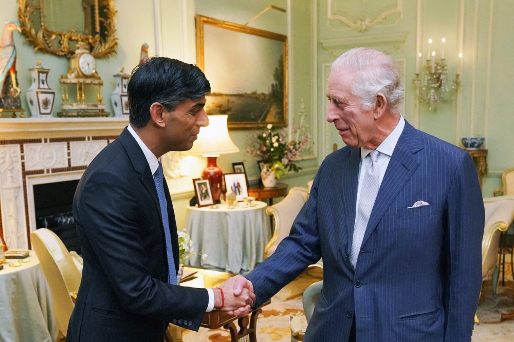 Britain's King Charles III shakes hands as he welcomes Britain's Prime Minister Rishi Sunak at Buckingham Palace, in central London, on February 21, 2024 for their first in-person audience since the King's diagnosis with cancer. — AFP pic