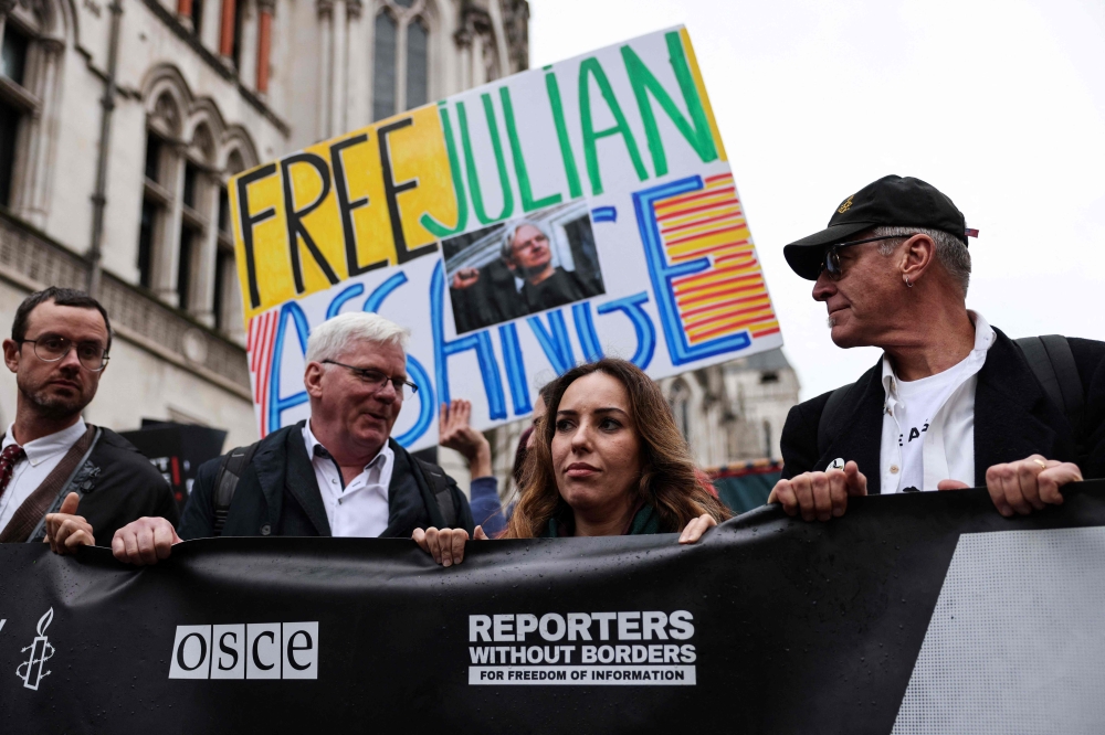 Wife of WikiLeaks founder Julian Assange, Stella Assange (2nd right), flanked by Wikileaks editor in chief Kristinn Hrafnsson (2nd left), takes part in a march from The Royal Courts of Justice, Britain's High Court, in central London on February 21, 2024, on the second day of a UK appeal by the WikiLeaks founder Assange against his extradition to the US.— AFP pic