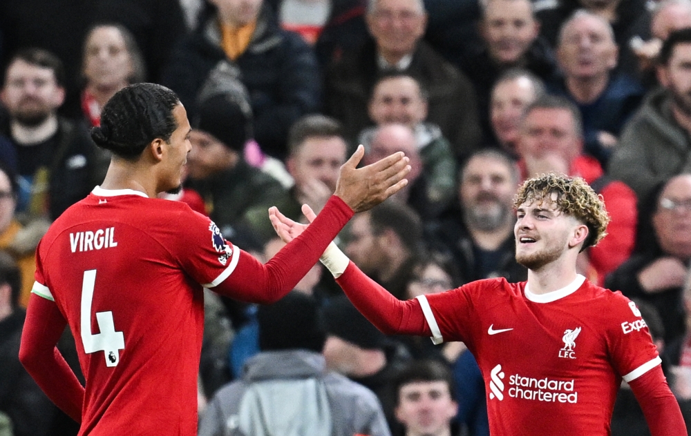 Liverpool's English midfielder #19 Harvey Elliott  celebrates with Liverpool's Dutch defender #04 Virgil van Dijk after scoring his team fourth goal during the English Premier League football match between Liverpool and Luton Town at Anfield in Liverpool, north west England on February 21, 2024. — AFP pic