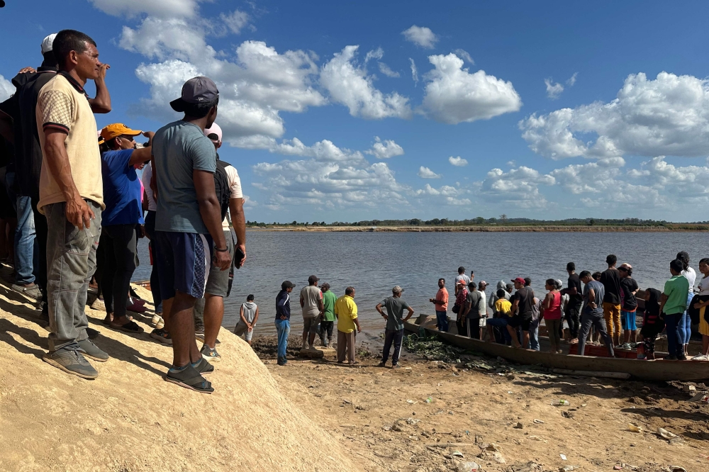 Relatives wait to receive the bodies of the miners that died after the collapse of a remote illegal mine, at Puerto Guacara in La Paragua, Bolivar state, Venezuela on February 21, 2024. — AFP pic