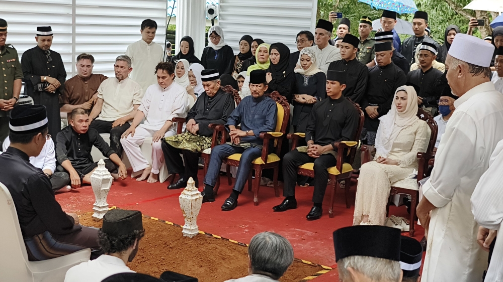 (Seated from fourth right) Wan Junaidi and Sultan Hassanal are seen during the burial ceremony. — Picture by Chimon Upon via Borneo Post