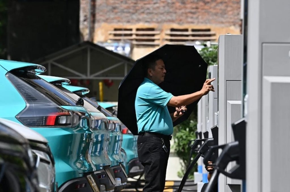 A driver charging a VinFast EV at a charging station in Hanoi on October 5, 2023. — AFP pic