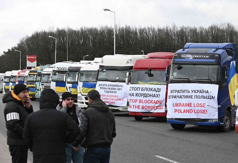 Ukrainian truck drivers take part in a protest against the blockade of the border by the Polish protesters at the Rava-Ruska border crossing point of the Ukrainian-Polish border, with trucks bannered with messages and Ukrainian flags February 20, 2024, amid the Russian invasion of Ukraine. — AFP pic