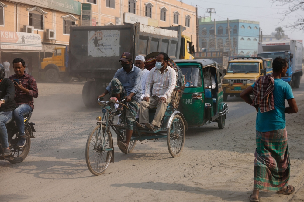 File photo of people wearing masks as they move through the dusty road as air quality decreases during dry season in Dhaka, Bangladesh, February 19, 2024. — Reuters pic