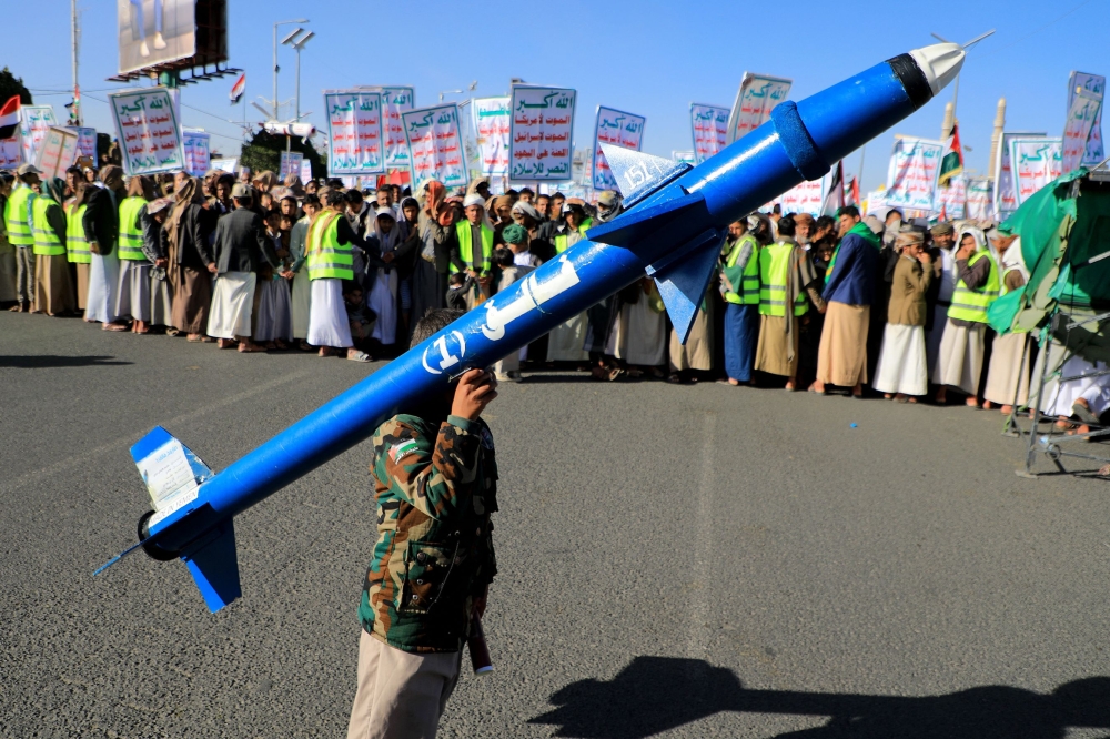 A demonstrator carries a mock rocket during a rally in the Houthi-run capital Sanaa. — AFP pic