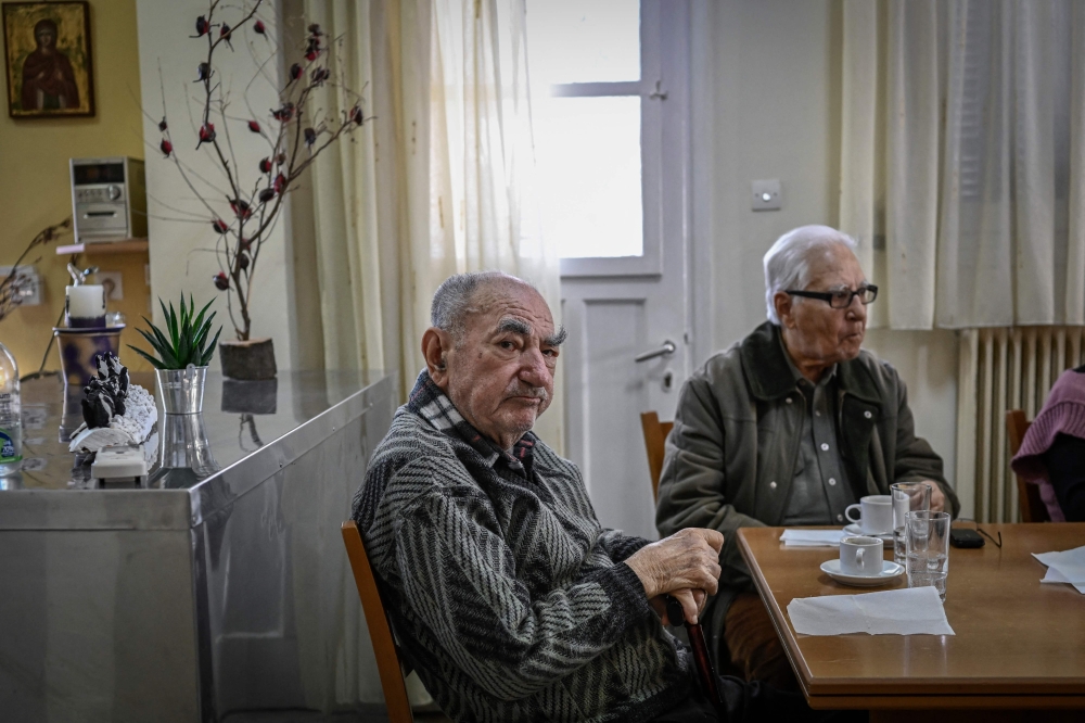 An elderly man sits inside an open care centre for elderly people, in Athens on February 2, 2024. — AFP pic