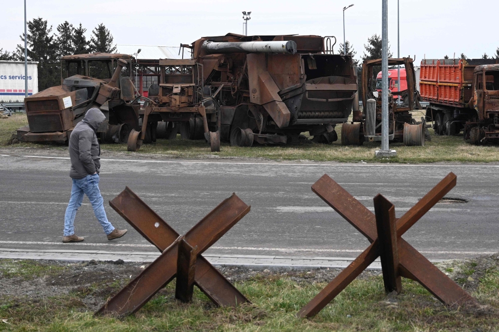 A man walks past the destroyed Ukrainian agricultural vehicles that were brought to the Ukrainian-Polish border by Ukrainian farmers at the Krakovets border crossing on February 24, 2024, on the second anniversary of Russia's invasion of Ukraine. — AFP pic