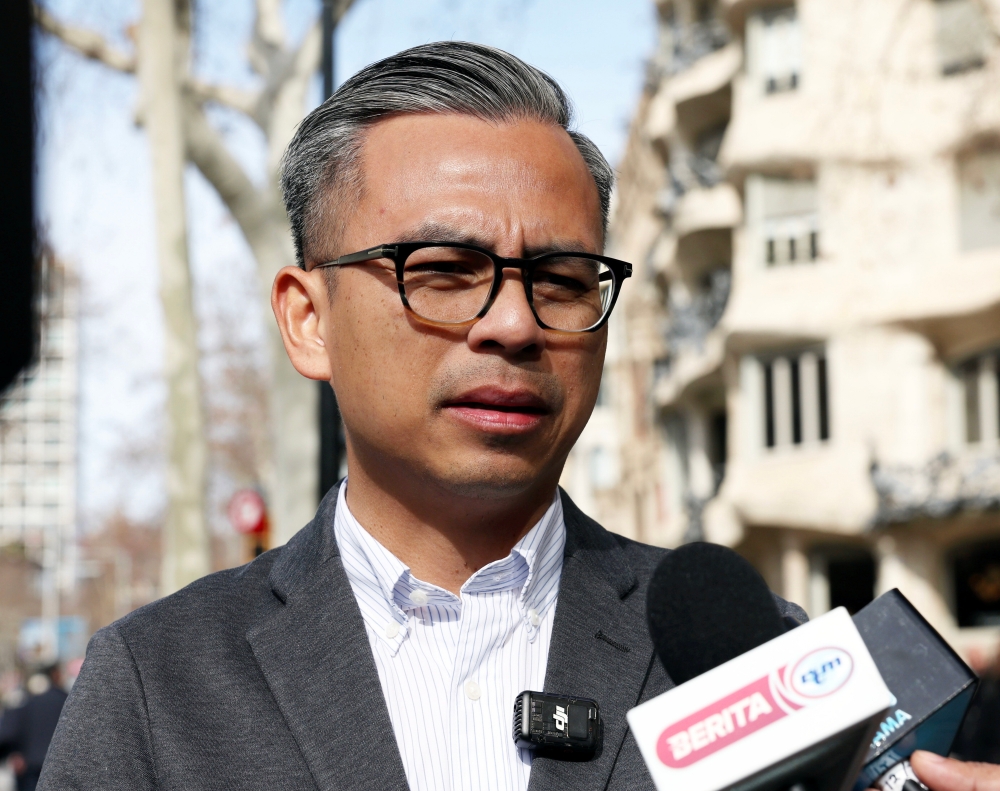 Communications Minister Fahmi Fadzil speaks to reporters in Barcelona February 25, 2024. — Bernama pic