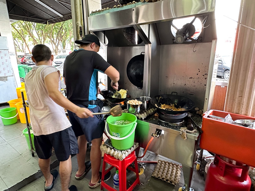 There are two cooking stations set up to fry rice and noodles