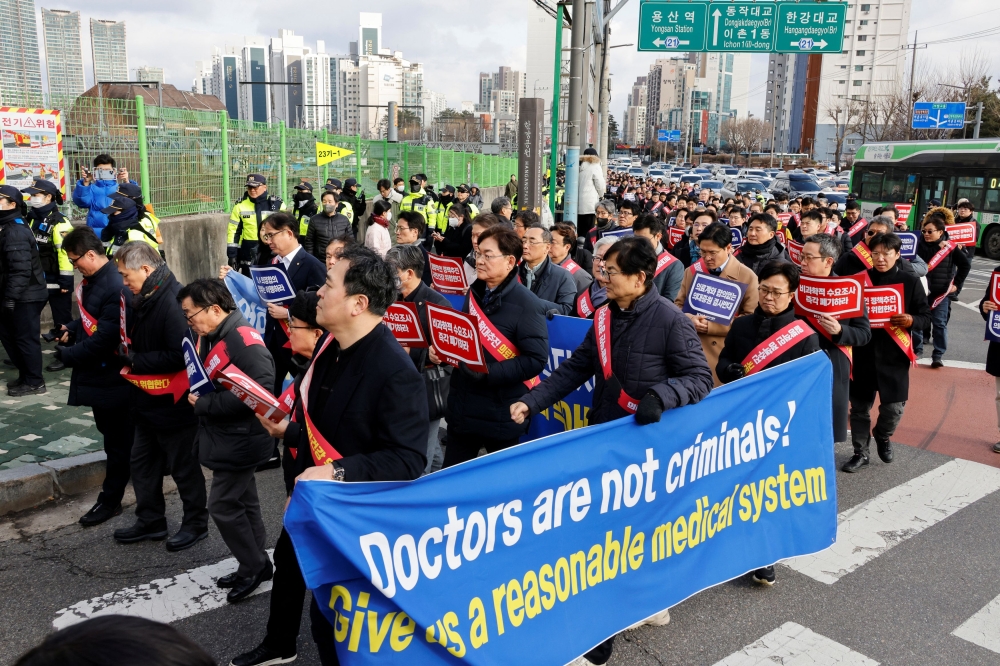 South Korean doctors march to protest against the government medical policy in front of the Presidential office in Seoul, South Korea, February 25, 2024. — Reuters pic
