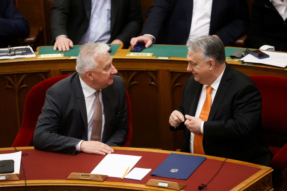 Hungarian Prime Minister Viktor Orban and Deputy Prime Minister Zsolt Semjen speak as they attend the spring session of parliament in Budapest, Hungary, February 26, 2024. — Reuters pic